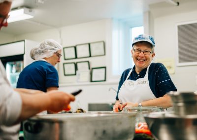 Raw carrot employee smiling in the soup Kitchen.