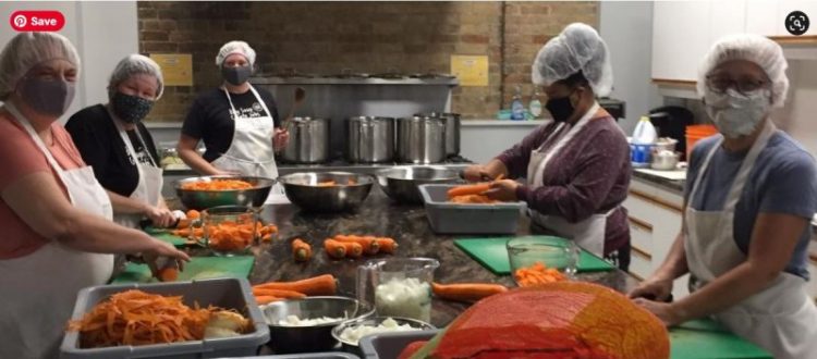 five people cutting carrots in the Raw Carrot Kitchen.